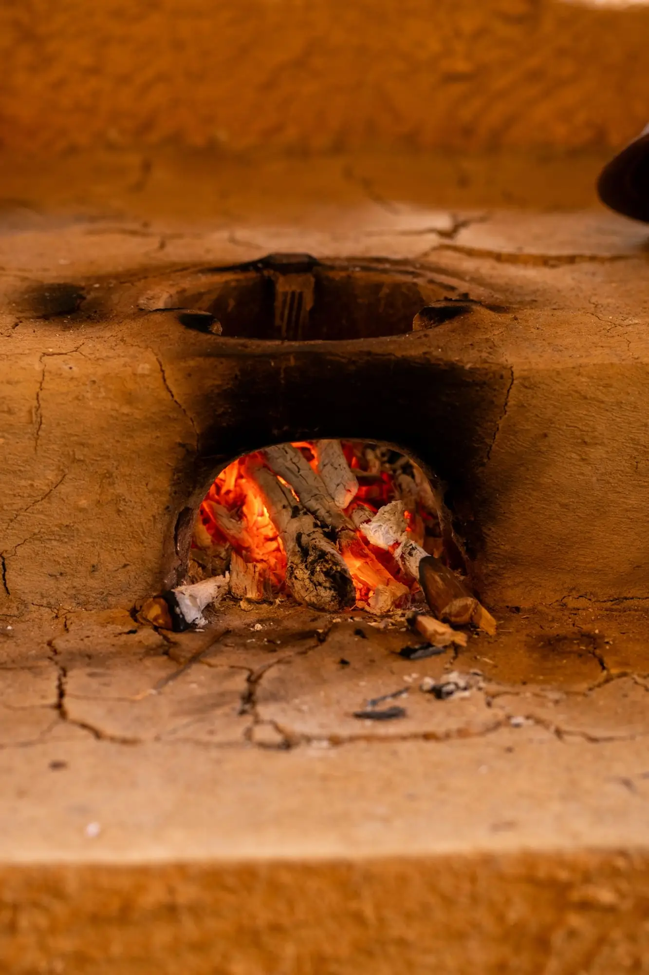 A wood fire burning in the clay hearth